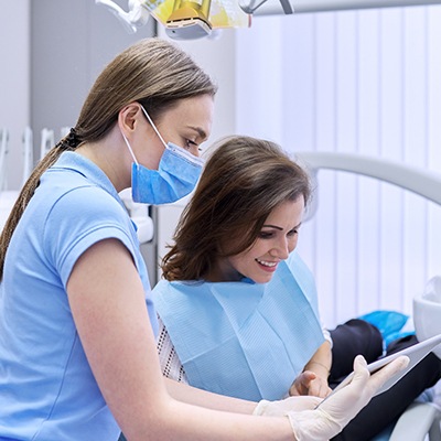 a dental assistant educating a patient 